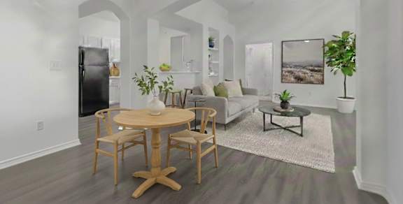 A spacious room with wooden flooring and white walls.