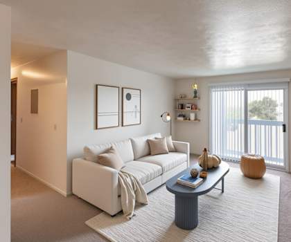 A living room with a white couch and a coffee table.
