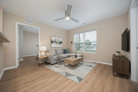 A living room with a couch, a coffee table, and a television.