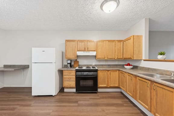 A kitchen with wooden cabinets and a white refrigerator.