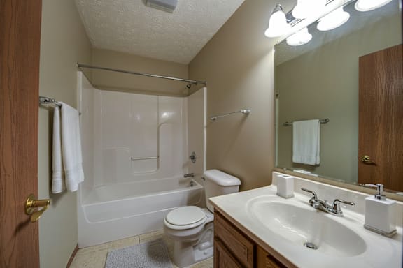 A bathroom with a toilet, sink, and bathtub.