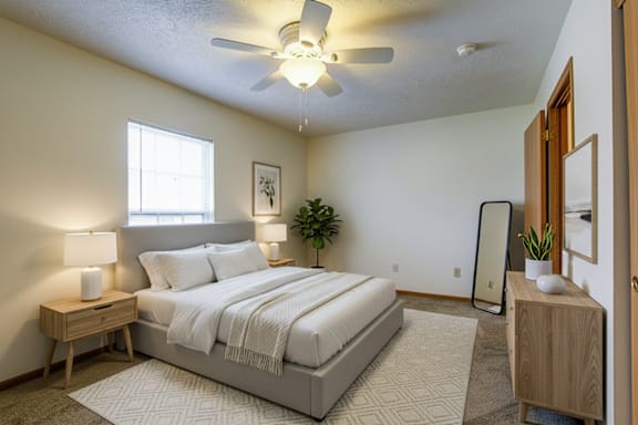 A bedroom with a bed, nightstands, and a ceiling fan.
