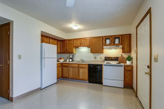 A kitchen with wooden cabinets and black appliances.