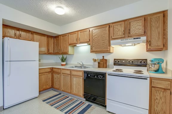 A kitchen with wooden cabinets and white appliances.