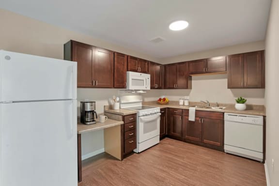 A kitchen with brown cabinets and white appliances.