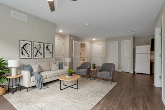 A living room with a white couch, grey armchairs, and a coffee table.