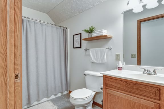 A bathroom with a toilet, sink, and shower.