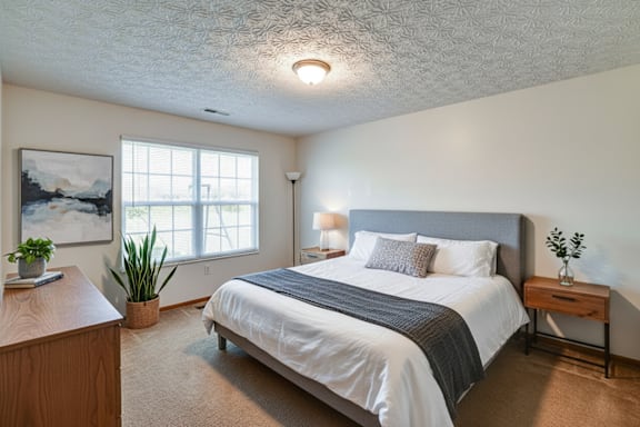 A bedroom with a large bed and a painting on the wall.