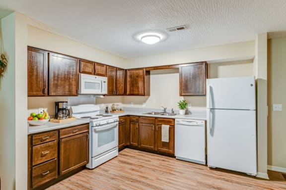 A kitchen with wooden cabinets and white appliances.