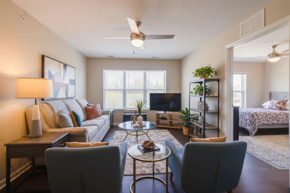 A living room with a grey couch, a coffee table, and a ceiling fan.