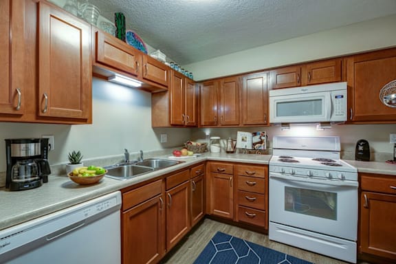 A kitchen with wooden cabinets and white appliances.