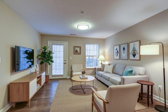 A living room with a couch, chair, and television.