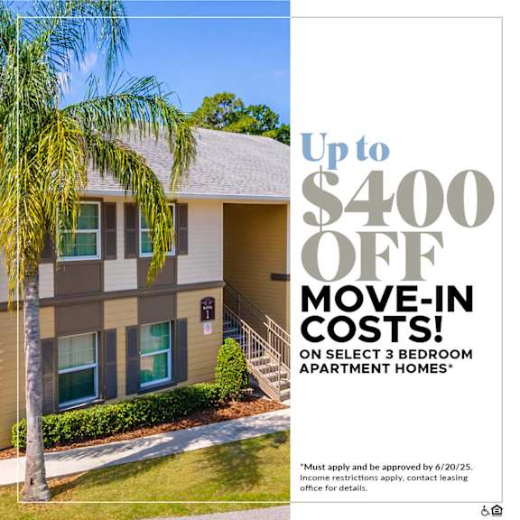 A building with a tree in front and a sign offering up to $400 off move-in costs.
