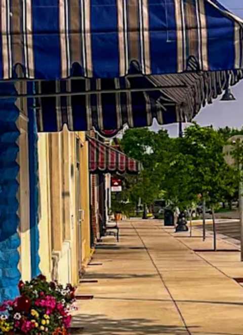 A street view of a town with a car parked on the side of the road. at Ridgeview Apartments, Fortville, IN, 46060