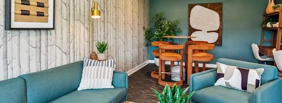 A living room with a blue couch and a wooden shelf.