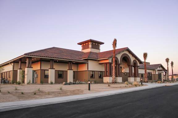 A building with a red tile roof and a palm tree in front.