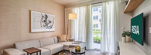 a living room with a couch and a table with a vase of flowers on it