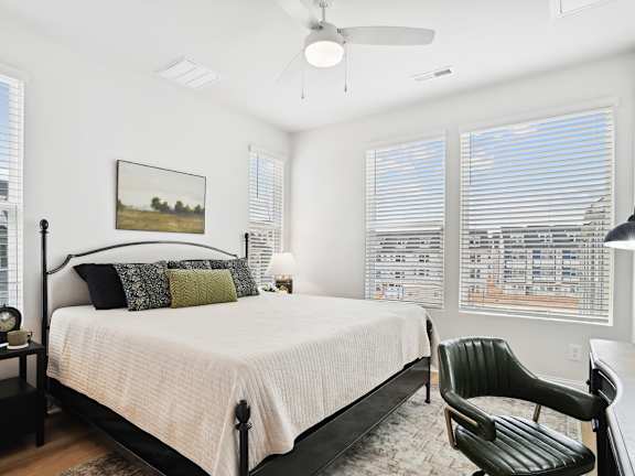 A bedroom with a large bed and a chair.
