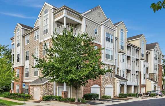 A large apartment building with multiple balconies and a mix of brick and siding exteriors.