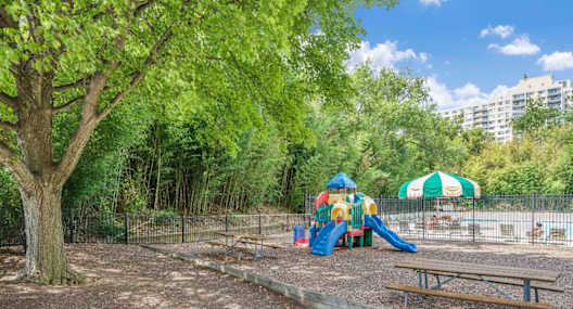 A playground with a slide, swings, and a picnic table.