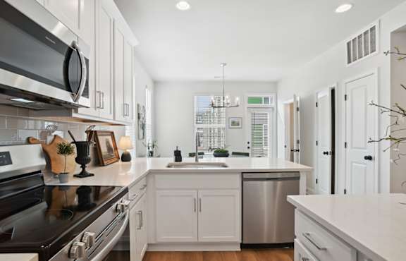 A modern kitchen with white cabinets and stainless steel appliances.
