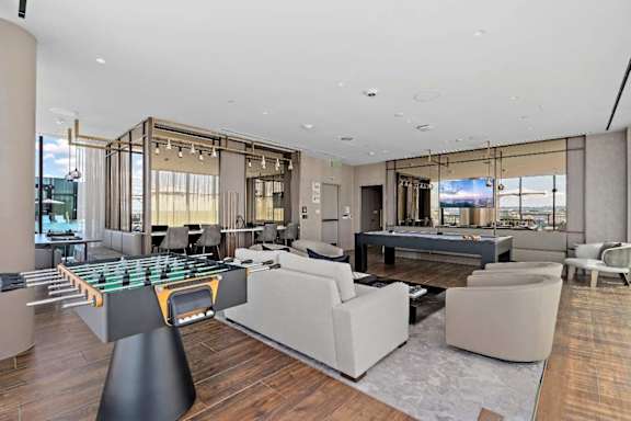 A modern living room with a foosball table in the center.