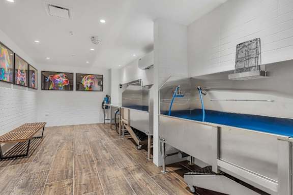 A kitchen with a long stainless steel table and a bench.