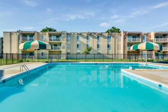 A swimming pool in front of apartment buildings.