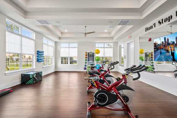 A room with a row of stationary bikes and a sign that says "Don't Stop".