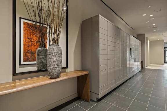 A long hallway with a bench and vases on it.