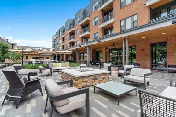 A patio area with chairs and tables in front of a building.