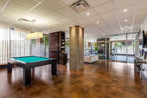 A room with a pool table and a bar.