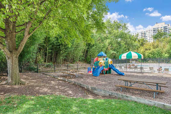 A playground with a slide, swings, and a picnic table.