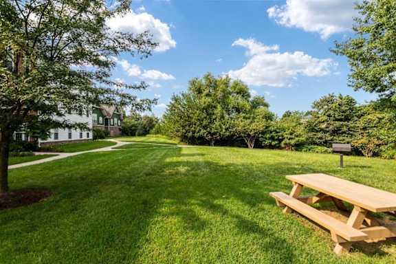 A picnic table sits in the middle of a grassy field.