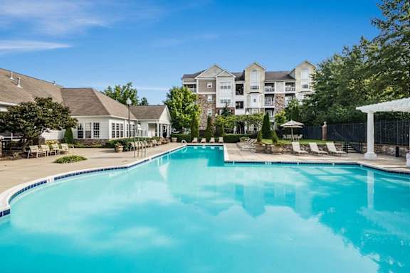 A large swimming pool in front of a resort.