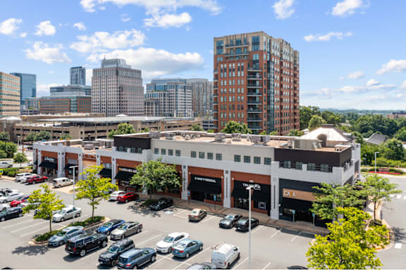 A parking lot with cars and a building in the background.