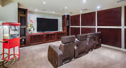 a living room with leather chairs and a television
