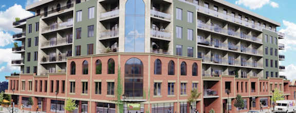 A large building with a red brick facade and a green balcony.