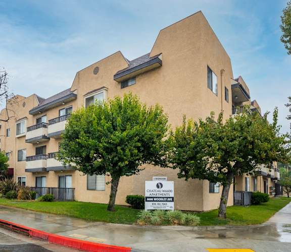 A building with a sign that says "Chateau Woods Apartments".