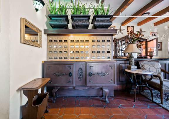 A wooden desk with drawers and a mirror above it.