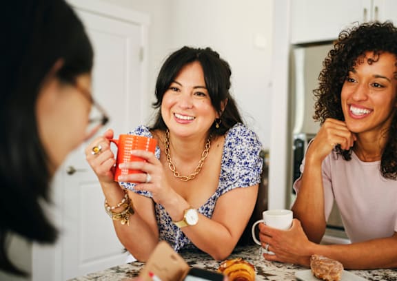 three women sitting at a table drinking coffee and talking at Tides on McDowell, Phoenix, Arizona 85035