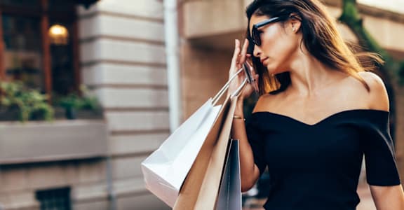 a woman talking on her cell phone while holding shopping bags at Tides on McDowell, Phoenix, Arizona 85035