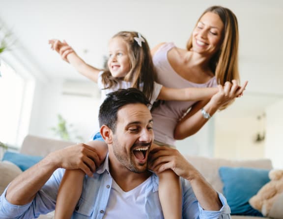 a man and woman sitting on a couch with their daughters