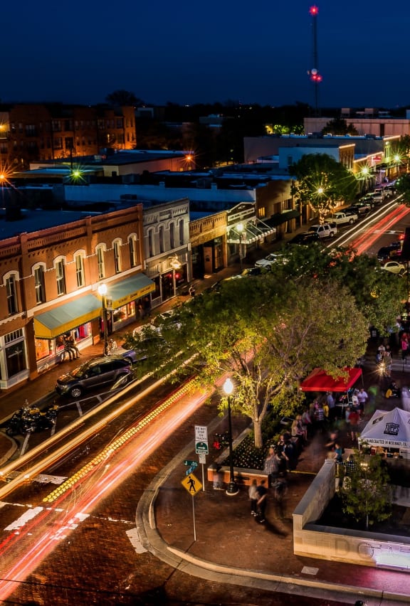 a night time view of a busy city street with traffic and a restaurant