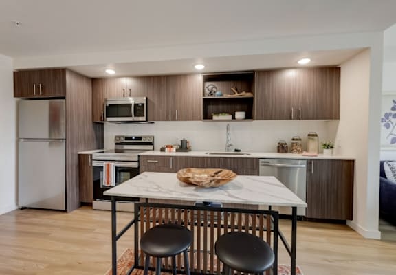 a kitchen with a large center island with a marble countertop