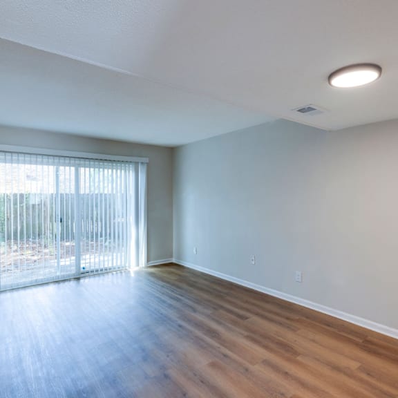A room with a sliding glass door and wooden flooring. at Savan Pointe, Savannah, Georgia