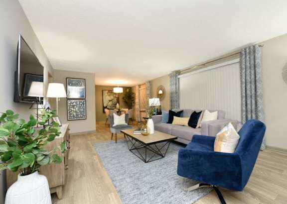 A living room with a blue chair and a grey couch.
