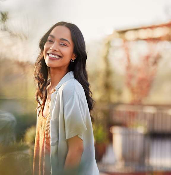 A woman with long hair is standing outdoors.
