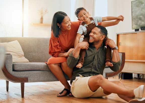 A family of three is having fun in their living room.