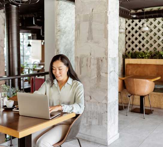 a woman sitting at a table with a laptop